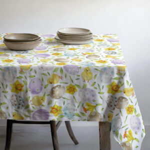 perspektywa stołu pokazująca krawędź obrusu z wiosennym wzorem i zastawą ceramiczną
