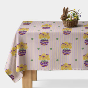 Obrus z motywem pastelowych pionowych pasów i żółtych bratków w fioletowych doniczkach na stole z wielkanocną dekoracją