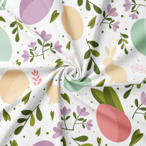 Zbliżenie na tkaninę z motywem pisanek, zajączków i gałązek, widoczna delikatna faktura materiału