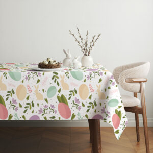 Aranżacja stołu z obrusem w pastelowy wzór, talerze i ceramiczne dekoracje wielkanocne