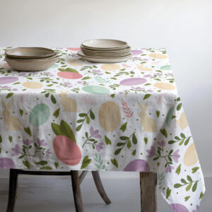 Widok stołu z zastawą i obrusem w motywy pisanek i liści, ujęcie pokazujące wzór na płaszczyźnie
