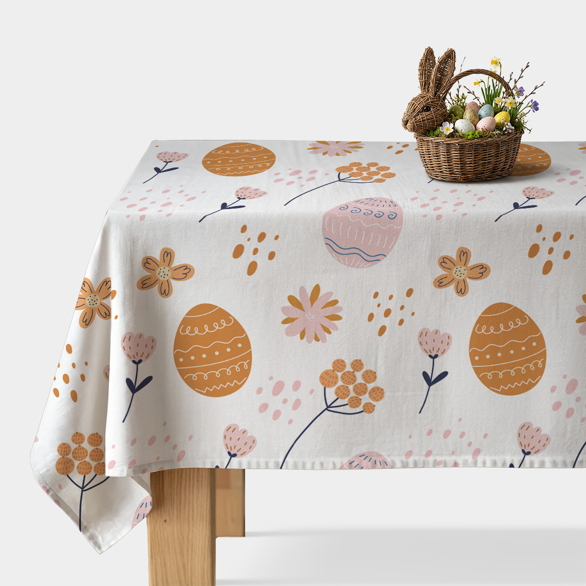 Obrus z motywem pisanek i kwiatów na białym tle z koszykiem wielkanocnym ujęcie ogólne