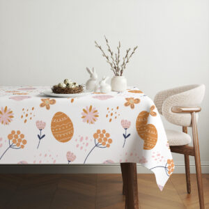 Aranżacja stołu z prostą zastawą i gałązkami w wazonie na obrusie z pisanek