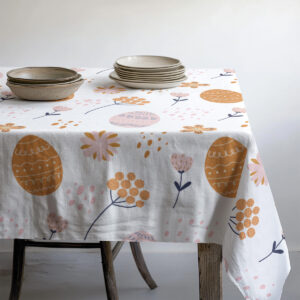 Widok rogu stołu z pofałdowaniem i wzorem pisanek oraz kwiatów