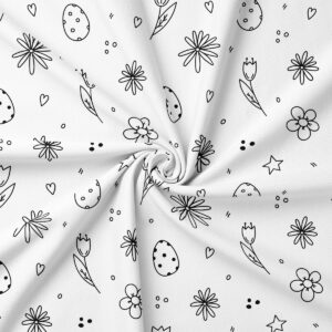 zbliżenie materiału z obrusowym wzorem pokazujące jajka, tulipany i drobne kwiaty na białym tle