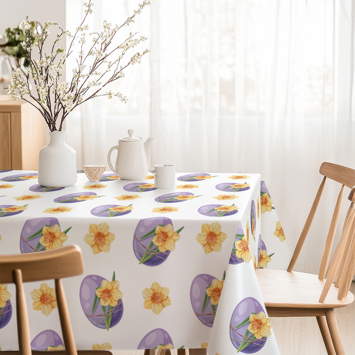 Jasne wnętrze z obrusem ozdobionym pisanek i żonkili, przy którym ustawiono krzesła i dekoracje