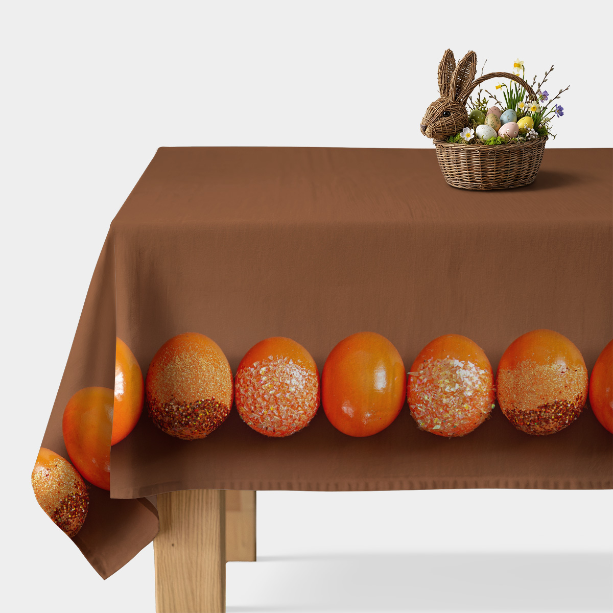 brązowy obrus na stole z pasem pomarańczowych pisanek wzdłuż krawędzi