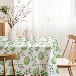 Jasne, przestronne wnętrze z obrusem w zielone jajka i gałązki oraz wazonem z kwiatami na stole