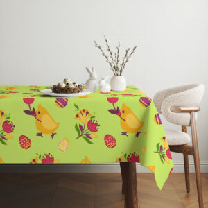 Aranżacja stołu z ceramicznymi zajączkami i baziówkami ustawionymi na obrusem w wiosenne wzory