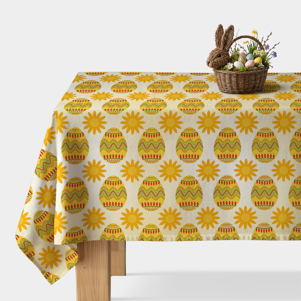 Widok główny obrusa z motywem pisanek i żółtych słoneczek oraz koszyk wielkanocny na rogu stołu