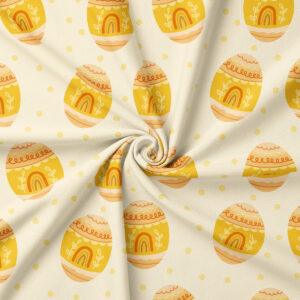 Zbliżenie na fakturę tkaniny i rysowane motywy pisanek w odcieniach żółci