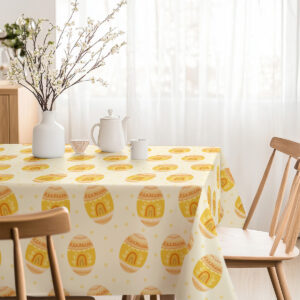 Jasna jadalnia z obrusem w żółte pisanki i bukietem gałązek w wazonie