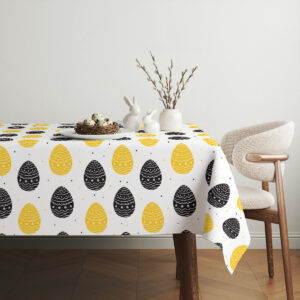 Aranżacja stołu z obrusem, ceramiczne zające i wiosenne gałązki na tle jasnego wnętrza