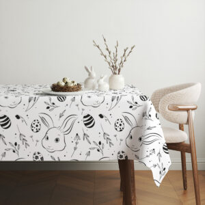 Aranżacja stołu z obrusem, ceramiczne zajączki i gałązki nadająca świąteczny charakter