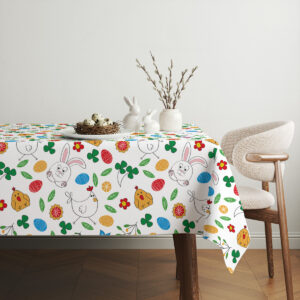 Aranżacja stołu z obrusem w wielkanocnym stylu, białe dekoracje i gałązki bazi nad stołem