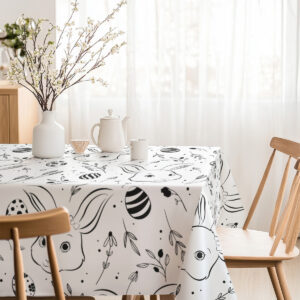 Jasna jadalnia z obrusem w czarno-białe króliczki i pisanki widoczna przy oknie