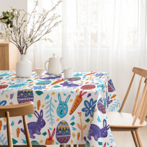 Widok wnętrza z nakrytym stołem, który podkreśla radosny wielkanocny motyw obrusu