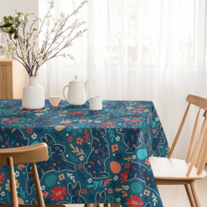 Jasne wnętrze jadalni z nakrytym stołem, obrus w motyw wielkanocnych zajączków i kwiatów w roli głównej