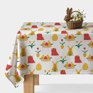 Obrus z wesołym wzorem zajączków i pisanek na białym tle, na stole koszyk wielkanocny z dekoracyjnymi jajkami