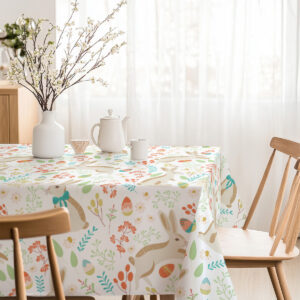 Jasne wnętrze jadalni z obrusem w wiosenne motywy, subtelnie uzupełnione drewnianymi krzesłami