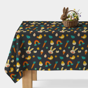 Obrus z ciemnym tłem ozdobiony kolorowymi wielkanocnymi motywami na stole z wiklinowym koszykiem z pisankami