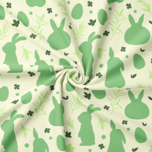 Zbliżenie na fakturę tkaniny i wzór zajączków oraz roślinnych akcentów w zielonych odcieniach