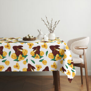 Aranżacja stołu z obrusem, dekoracjami wielkanocnymi i ceramicznymi zajączkami w jasnym wnętrzu