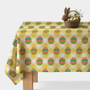 Obrus w żółtą kratę z kolorowymi pisankami na stole z koszykiem wielkanocnym