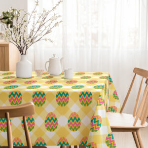 Jasne wnętrze jadalni z obrusem w żółtą kratę i pastelowymi wzorami pisanek