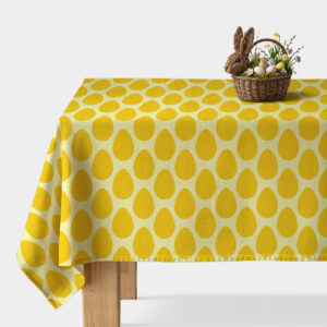 obrus z żółtym wzorem jajek na stole z wiklinowym koszykiem wielkanocnym