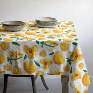 widok narożnika stołu z talerzami na obrusem ozdobionym pisankami i kwiatami