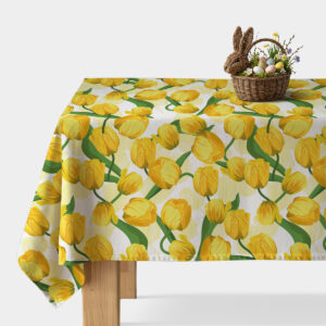 Obrus z motywem żółtych tulipanów rozłożony na stole z koszykiem wielkanocnym