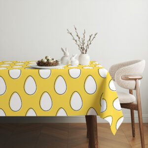 Aranżacja stołu z wazonem i ceramicznymi zajączkami prezentująca obrus w domowym wnętrzu