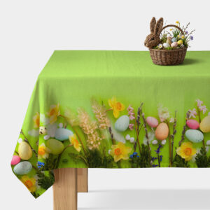 Jasnozielony obrus rozłożony na stole z dekoracyjnym brzegiem żonkilów i wielobarwnych pisanek