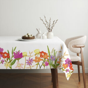 Obrus z malowanym pasem łąkowych kwiatów przy brzegu stołu, aranżacja z koszykiem z pisankami