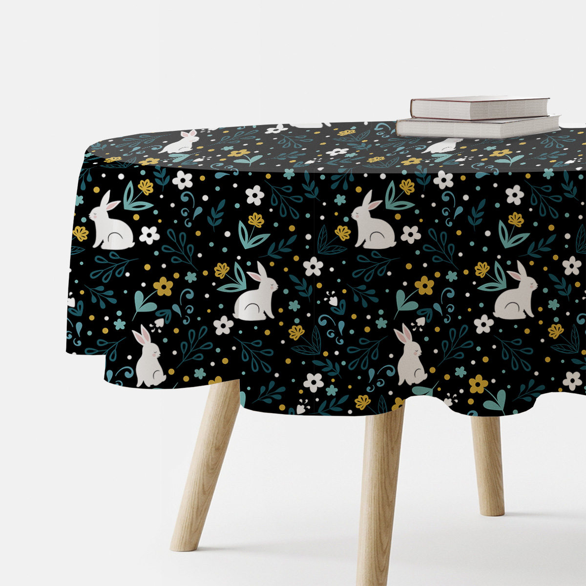 okrągły obrus na stole, czarne tło z białymi zajączkami i kolorowymi drobnymi kwiatami, ujęcie ogólne
