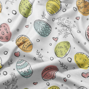 zbliżenie na tkaninę z kolorowymi pisankami i delikatnymi gałązkami