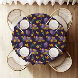 Widok z góry na nakryty stół z okrągłym obrusem zdobionym fioletowymi pisankami i żółtymi tulipanami