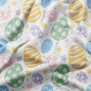 Zbliżenie na tkaninę z motywem pisanek i drobnych kwiatów, widoczna subtelna faktura materiału