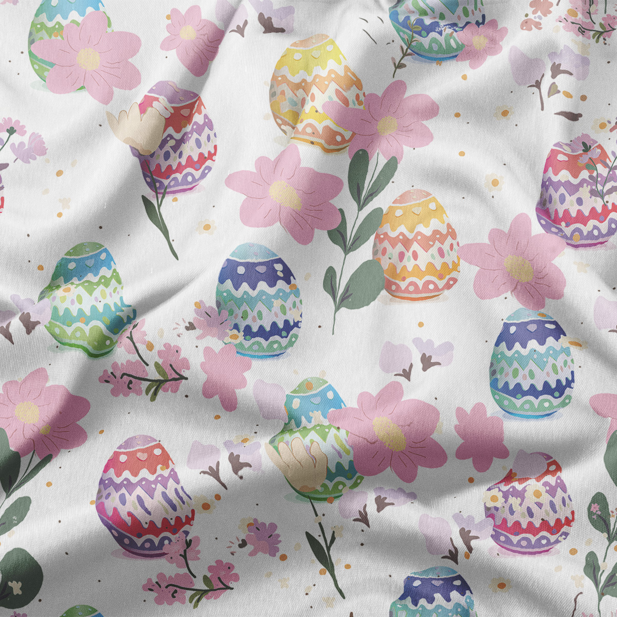 Zbliżenie na tkaninę z kolorowymi pisankami i delikatnymi kwiatami, widoczne akwarelowe przejścia barw