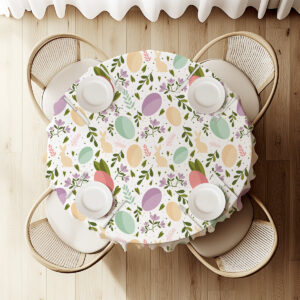 Widok z góry na okrągły stół nakryty obrusem z motywem pisanek i zajączków, ustawiony przy czterech krzesłach