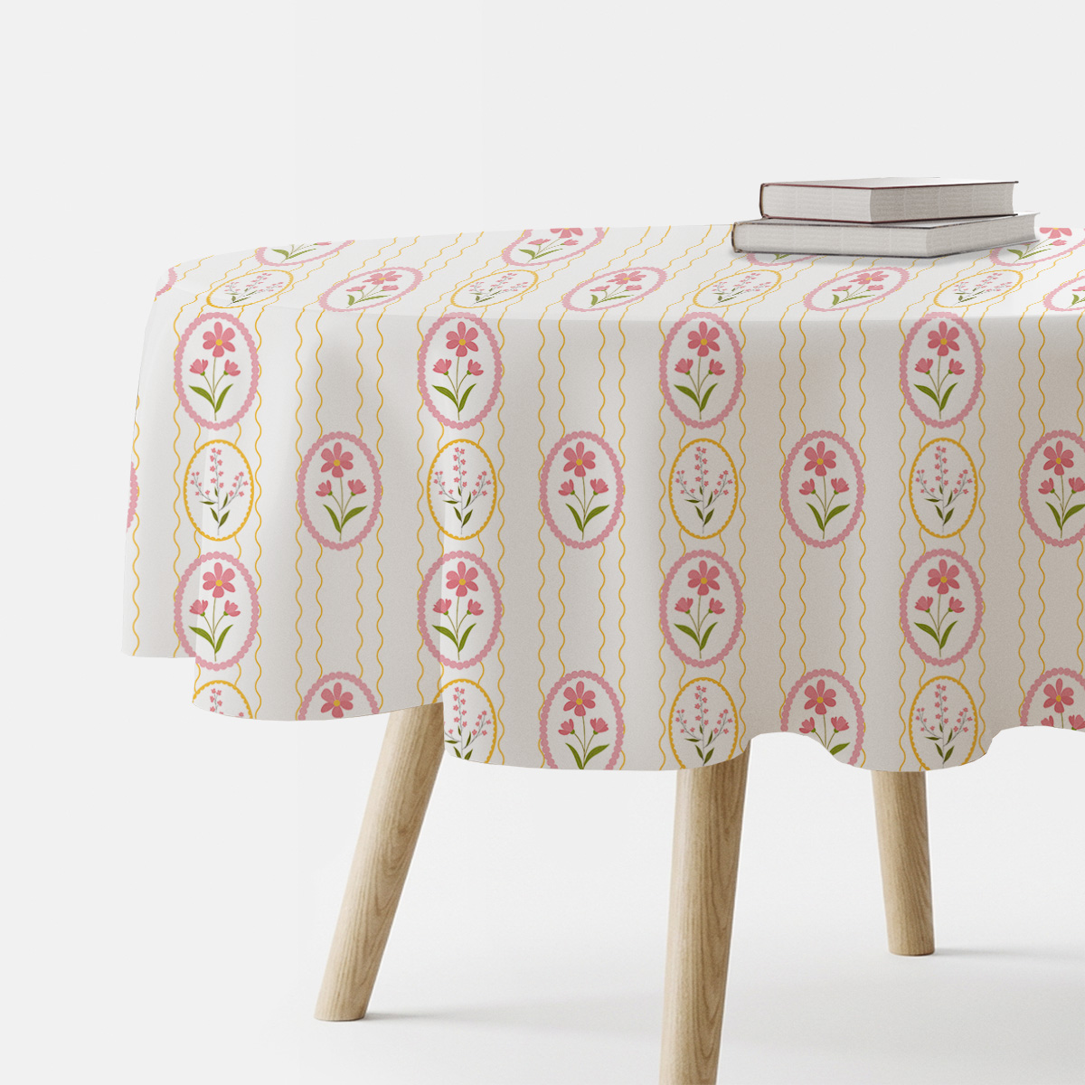 okrągły obrus z motywem pastelowych pisanek i różowych kwiatów na stole, widok boczny z książkami
