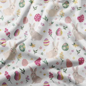 Zbliżenie na tkaninę z motywem zajączków, kolorowych pisanek i drobnych kwiatów