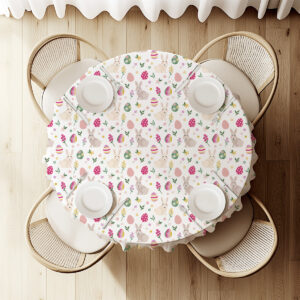 Widok z góry na okrągły stół nakryty obrusem z króliczkami i pisankami, ustawienie dla czterech osób