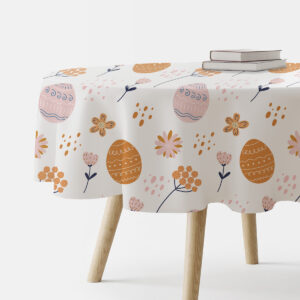 Okrągły obrus z motywem pisanek i delikatnych kwiatów na białym tle, aranżacja z książkami na stole