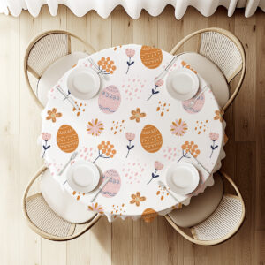 Widok z góry na nakryty stół z okrągłym obrusem w pastelowe pisanki i drobne kwiaty