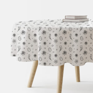 Okrągły obrus z czarno-białym wzorem pisanek i drobnych kwiatów na stole, widok z boku