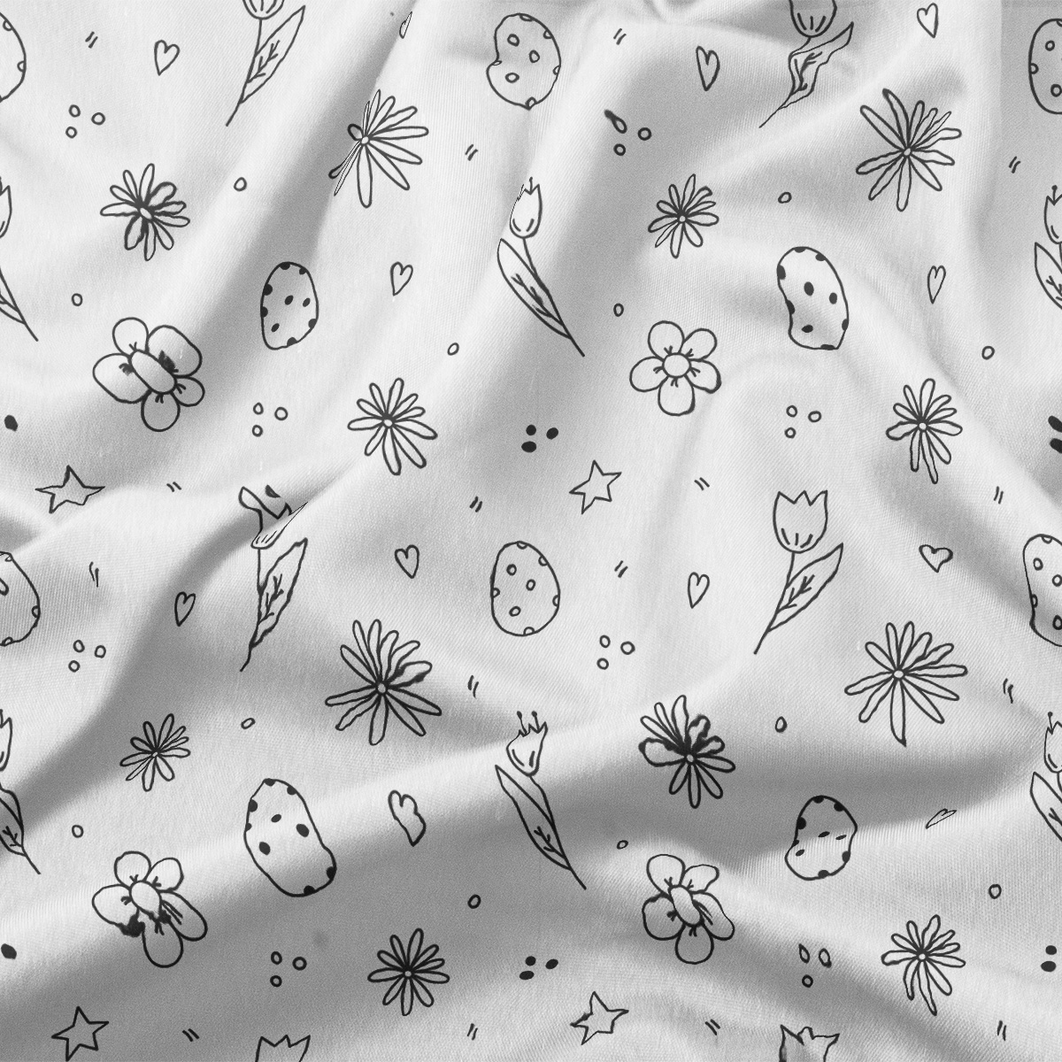 Zbliżenie na tkaninę z ręcznie rysowanymi motywami pisanek, tulipanów i drobnych kwiatów