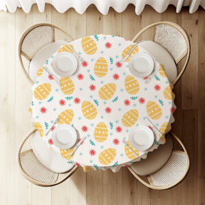 widok z góry na okrągły stół przykryty obrusem z motywem pisanek, nakrycie dla czterech osób