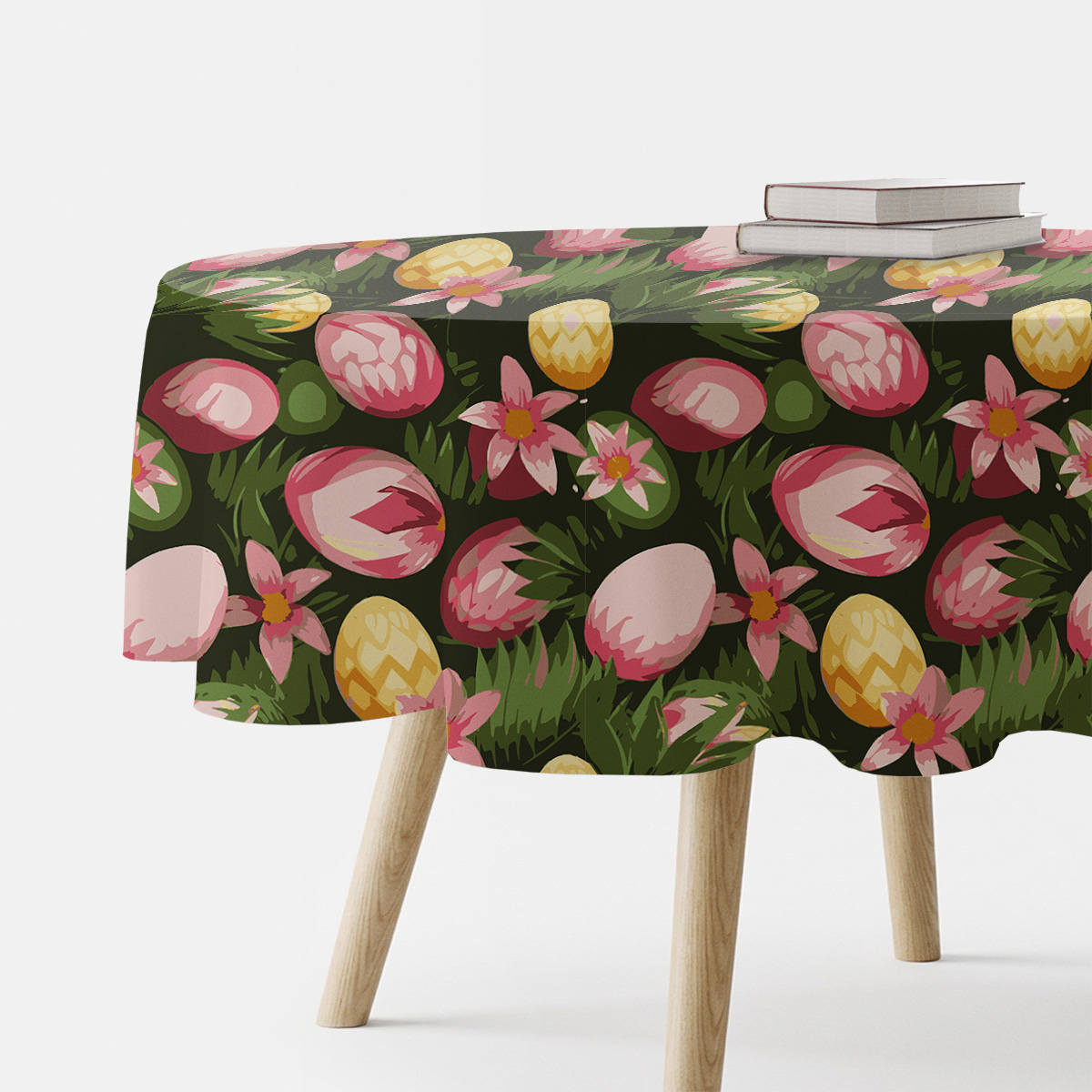 Okrągły obrus z motywem pisanek i różowych kwiatów na ciemnozielonym tle, ujęcie boczne stołu